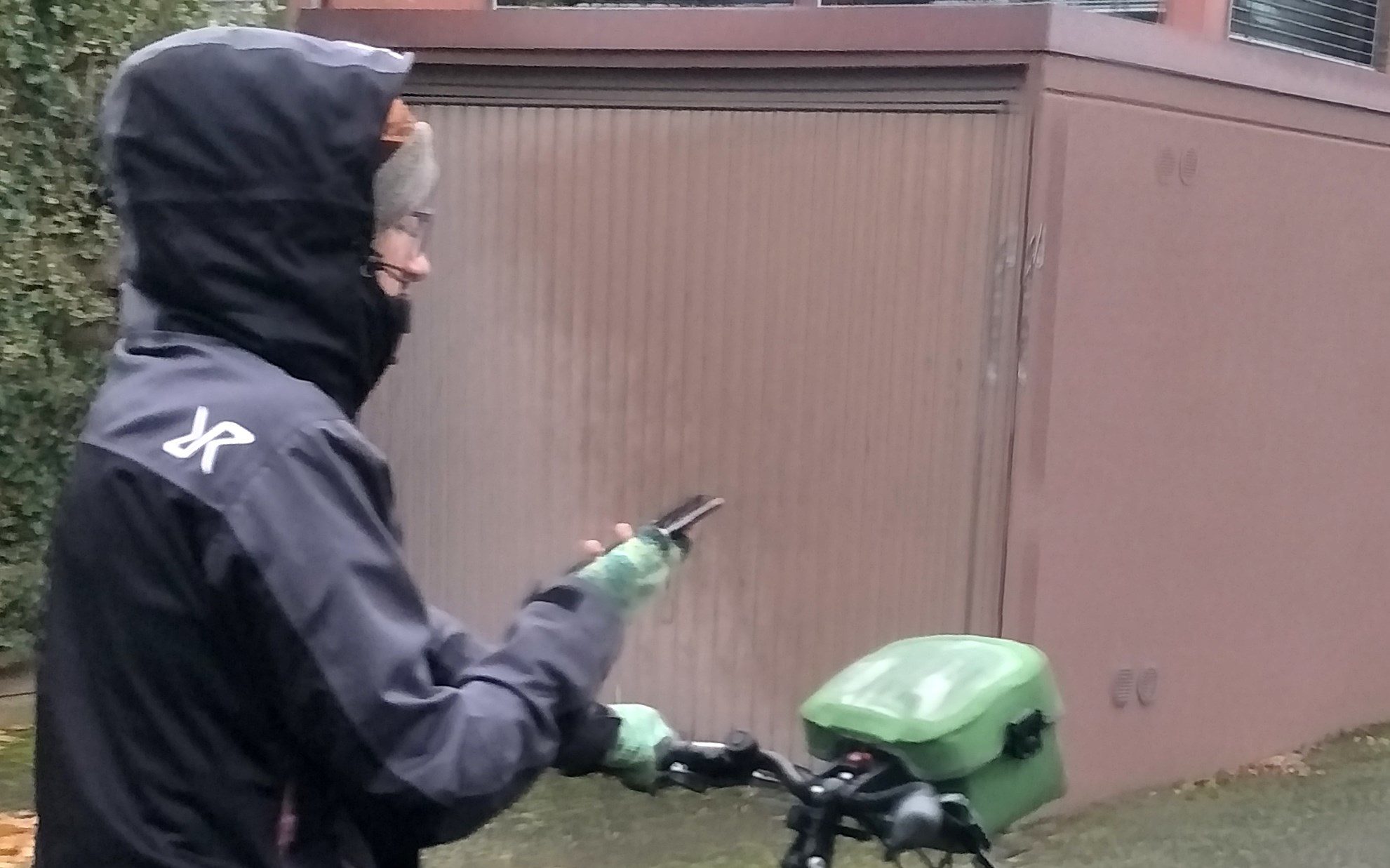 Frau auf Fahrrad mit Handy in der Hand.
